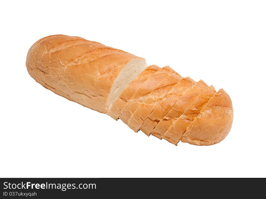 The white bread long loaf is cut on pieces. On a white background