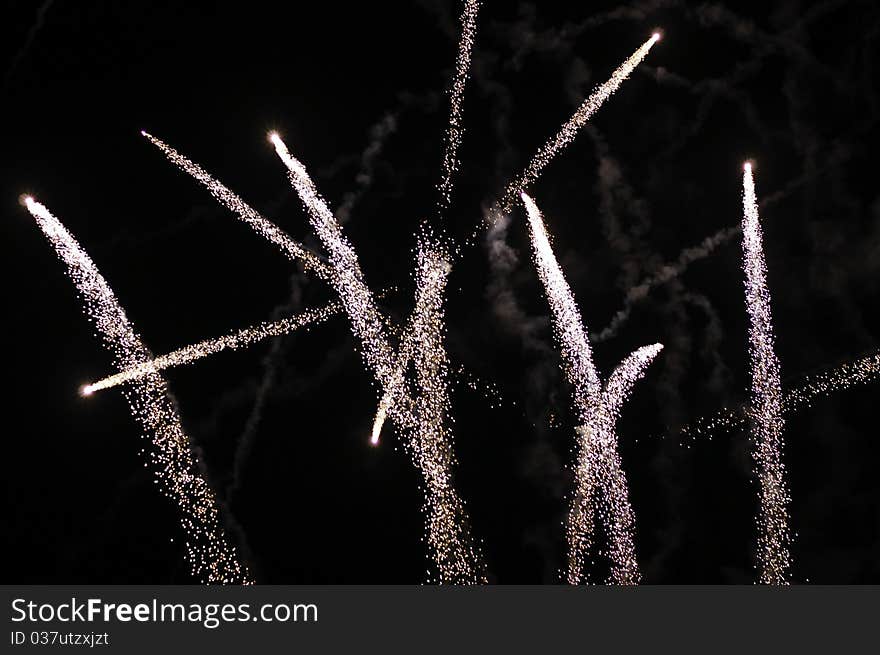 White comet like fireworks with smoke over night sky .