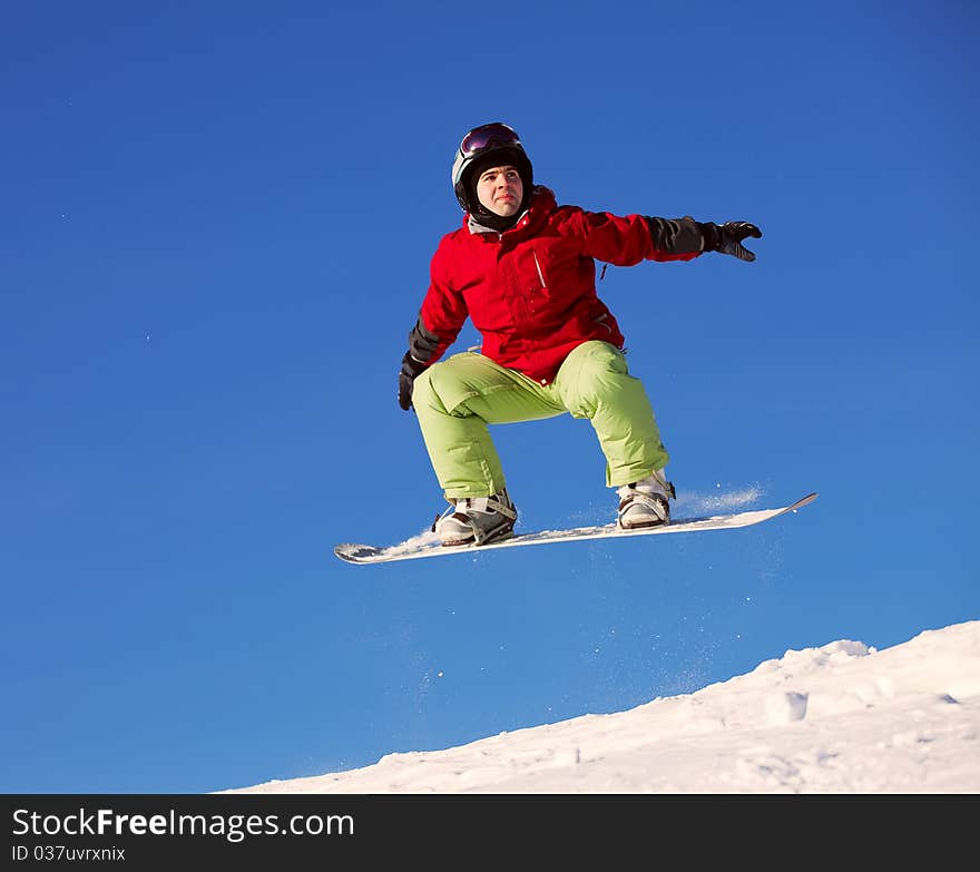 Snowboarder jumping through air with deep blue sky in background