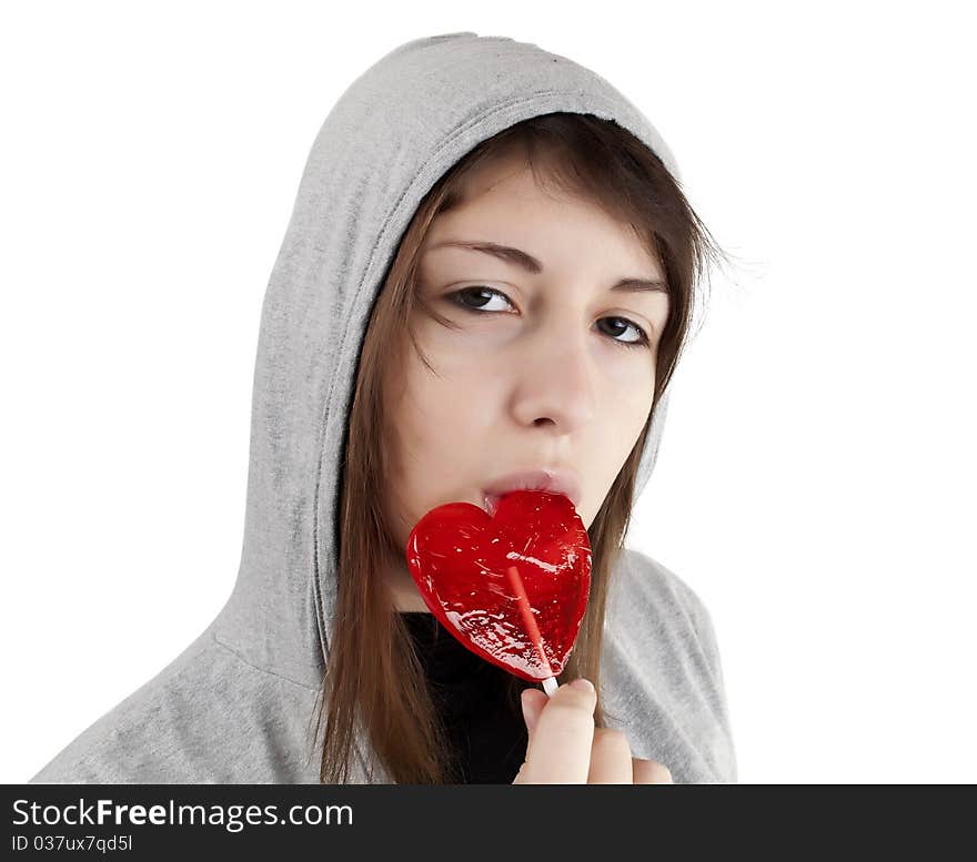 Candy red heart in the girl's lips on a white background