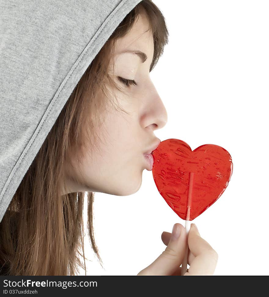 Candy red heart in the girl's lips on a white background