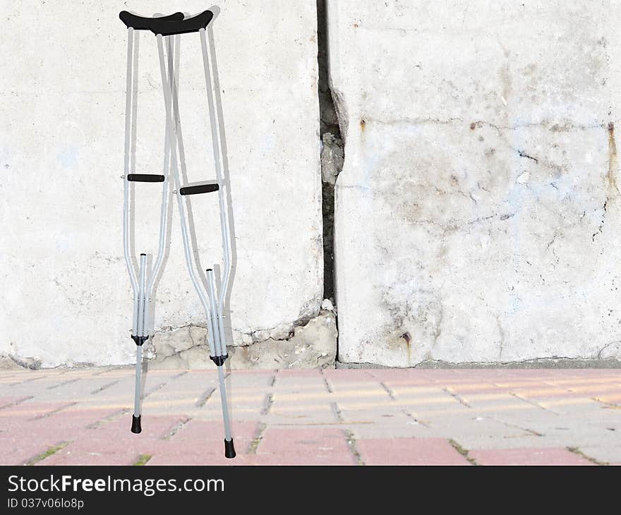 Background with the image of ferroconcrete wall and crutches. Background with the image of ferroconcrete wall and crutches