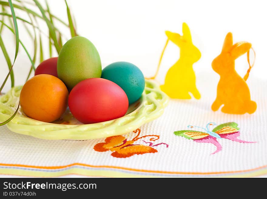 Easter eggs on a plate with rabbit decoration. Easter eggs on a plate with rabbit decoration