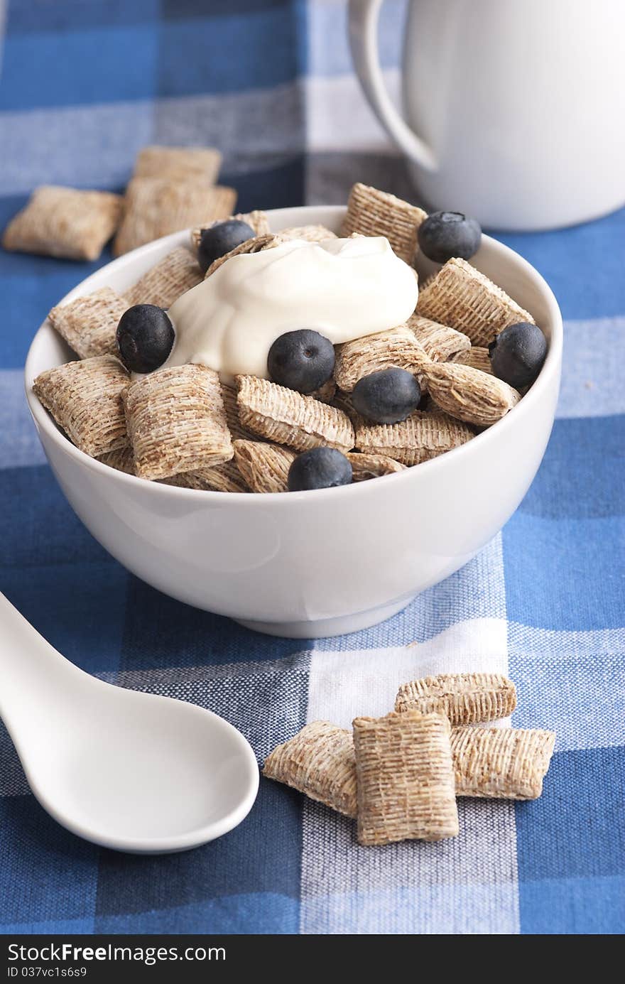 Wholegrain shredded wheat with creme fraiche and blueberries in a bowl