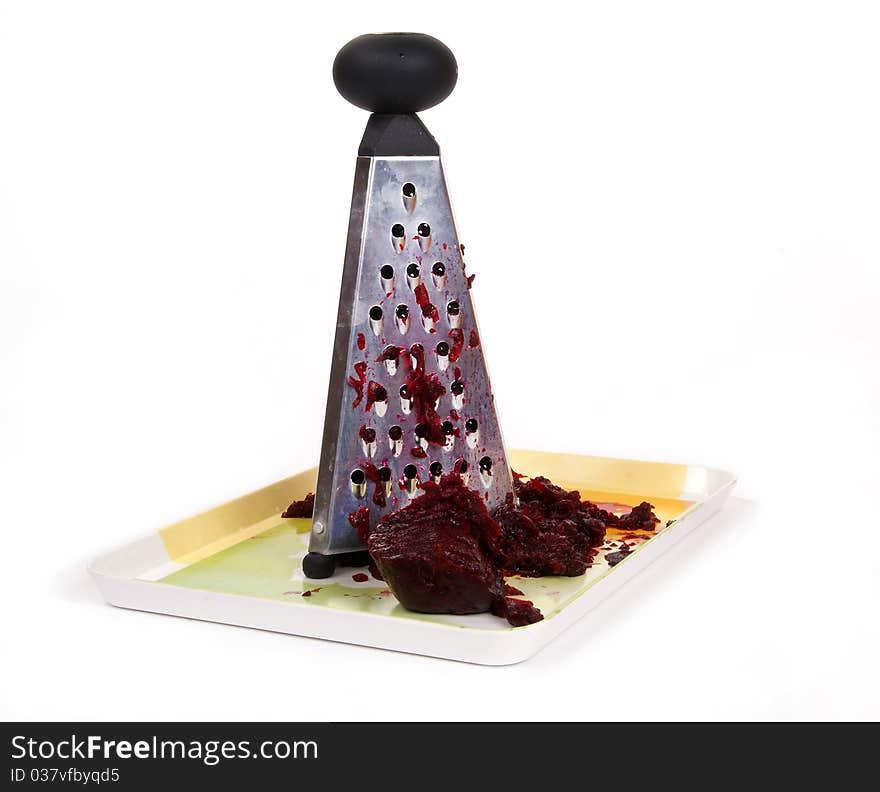 Metal kitchen grater with beets on a white background