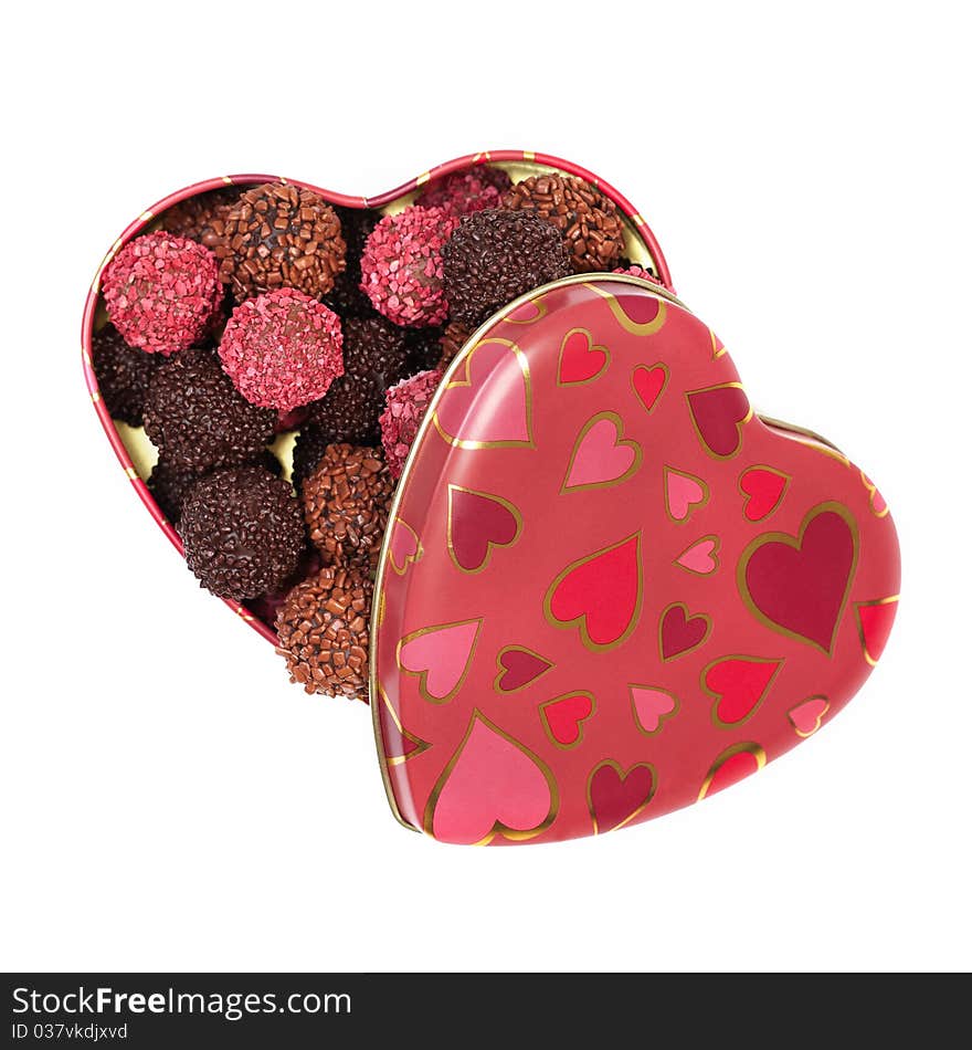 Chocolate truffles in heart shaped box on white background