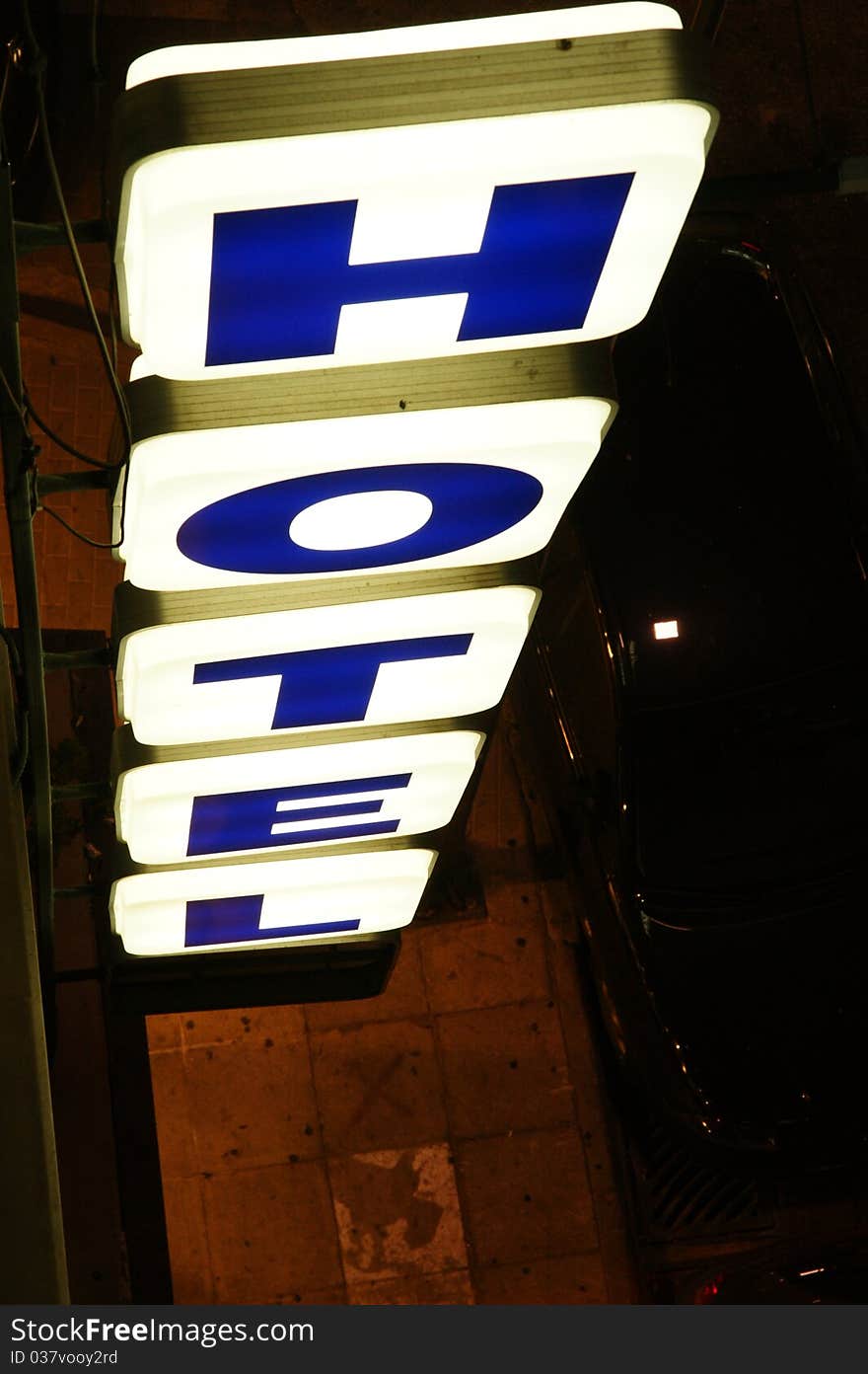 A luminous sign of hotel / inn along a city street. Top view.