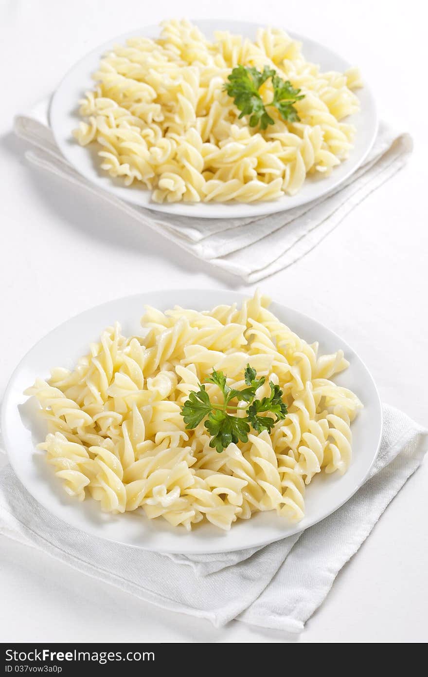 Two plates of pasta with parsley