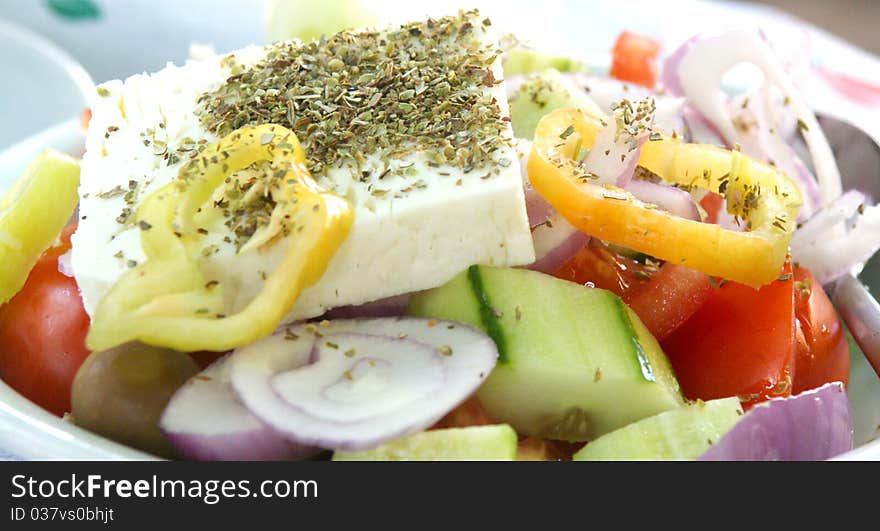 A plate of Greek Salad with onions, cuccumber