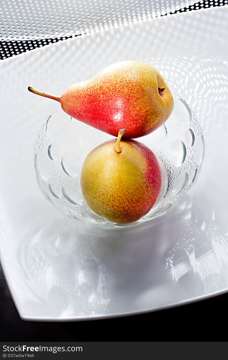 Two appetizing pears on the white glass plate. Two appetizing pears on the white glass plate