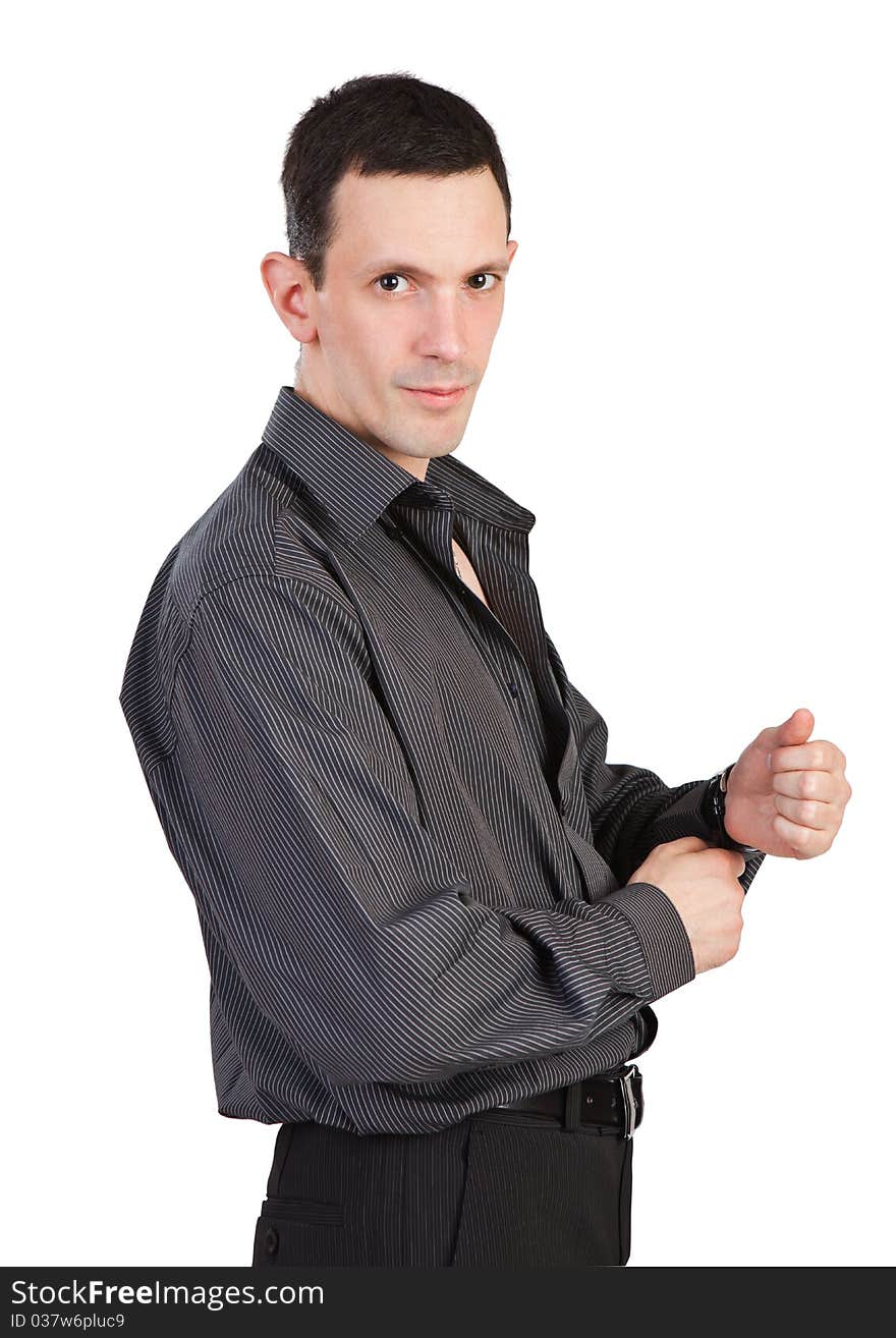 Young man buttoning-up a sleeve of his black shirt