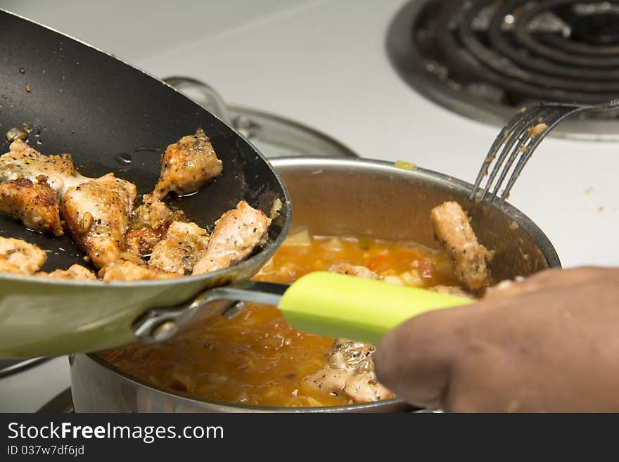 Adding fried fish into a special stew for dinner. Adding fried fish into a special stew for dinner