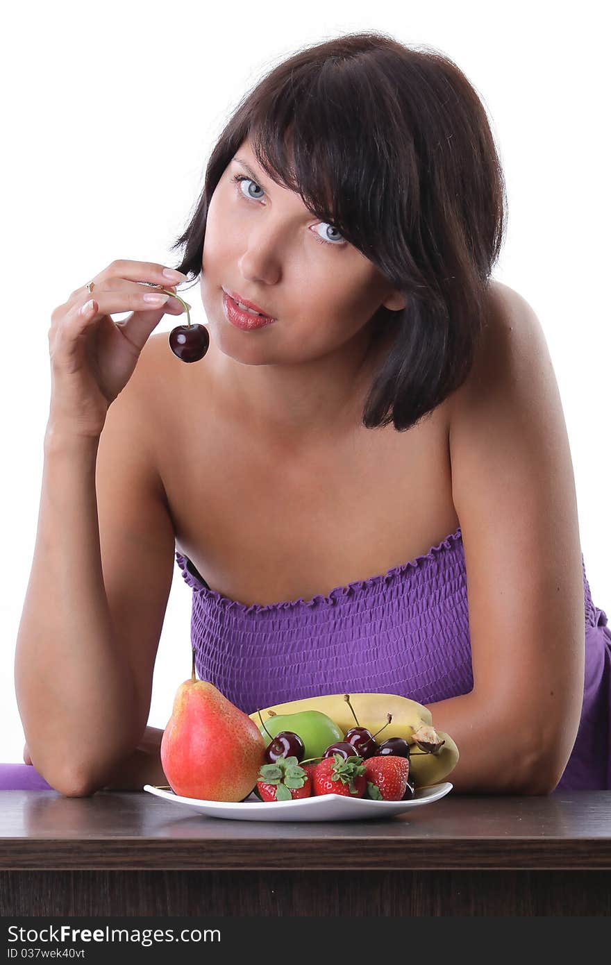 Cheerful tanned woman eating fruit and berrie. Cheerful tanned woman eating fruit and berrie