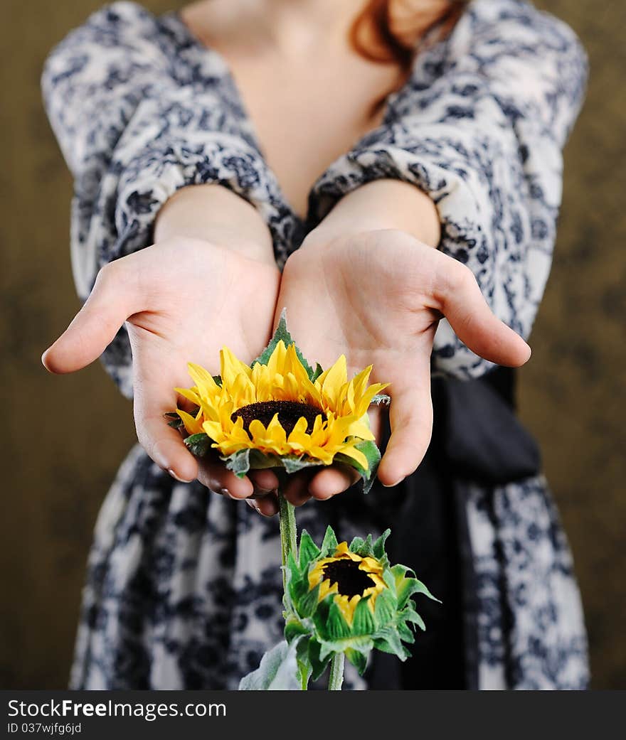 An image of young woman with sunflower