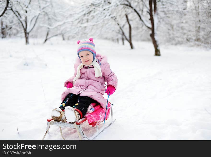 An image of a child sitting on sledge. An image of a child sitting on sledge