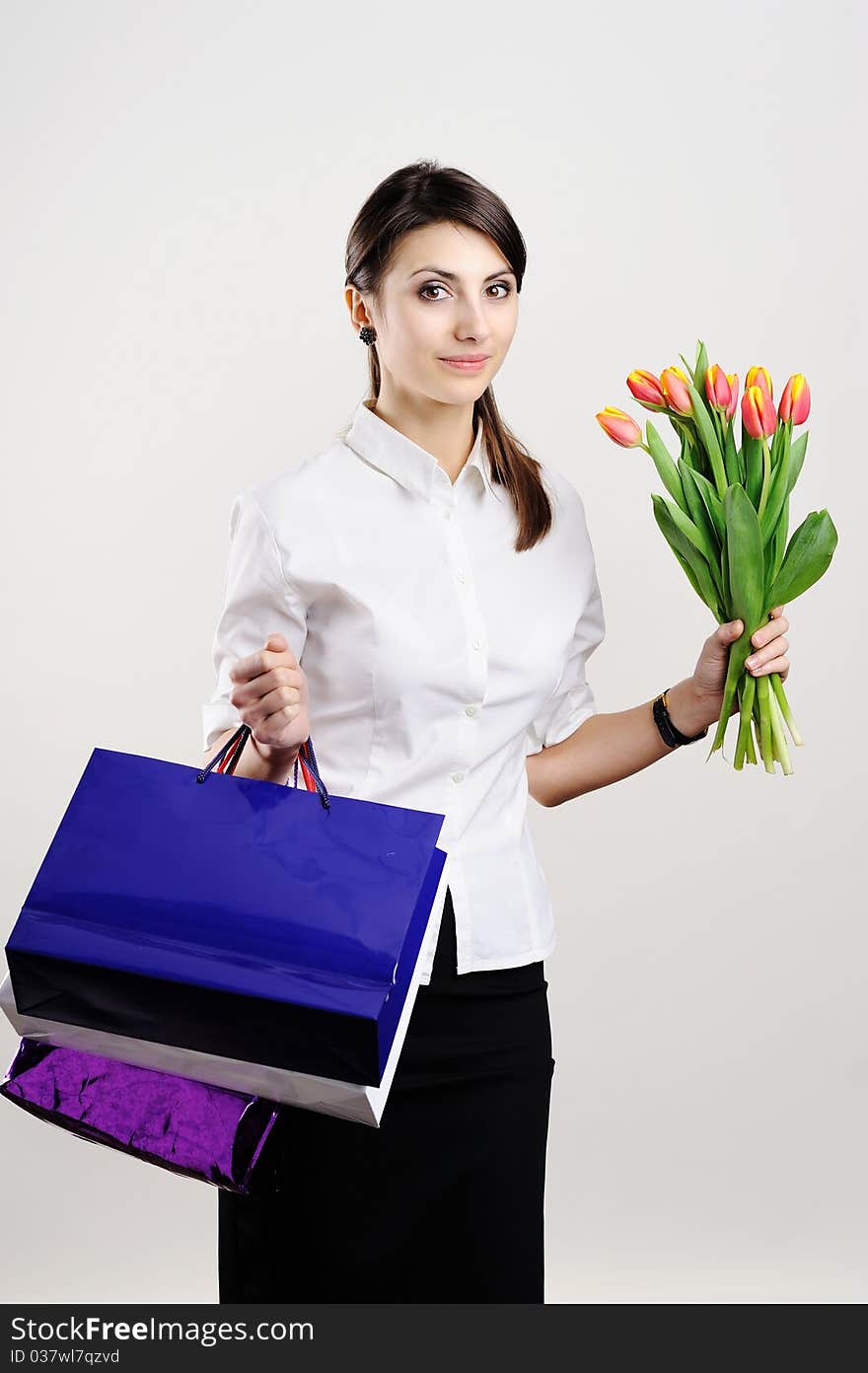 An image of a woman with paper bags and tulips. An image of a woman with paper bags and tulips