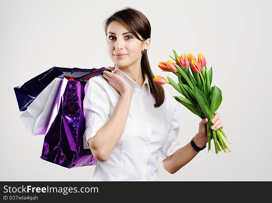 An image of a woman with paper bags and tulips. An image of a woman with paper bags and tulips