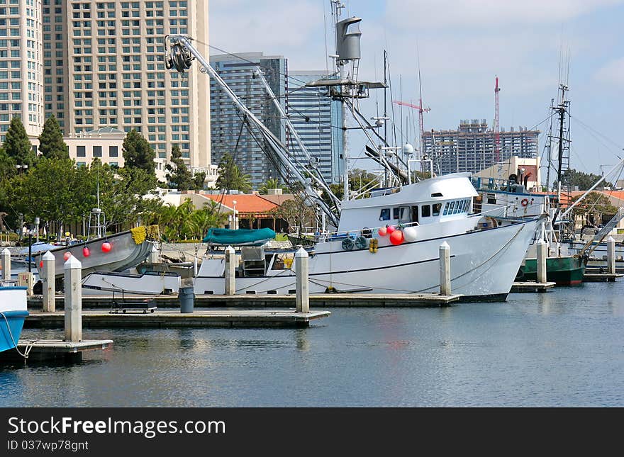 Fishing vessels and modern buildings at the marina in San Diego CA. Fishing vessels and modern buildings at the marina in San Diego CA.