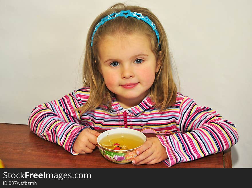 The child drinks grassy tea - useful to health