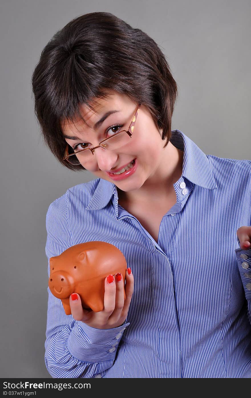 Young woman trying to get money from her piggy bank