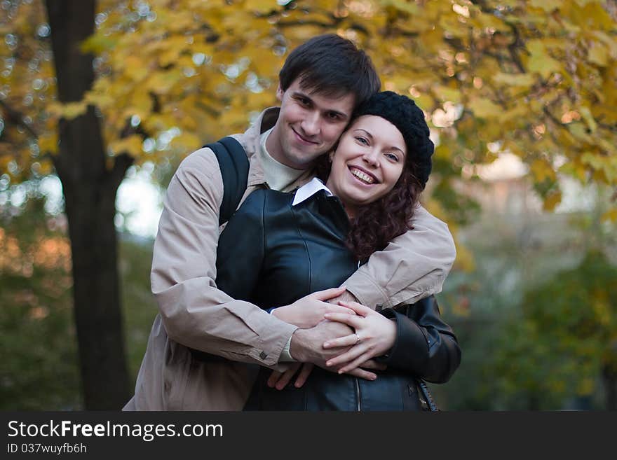 Smiling male and female in autumn park