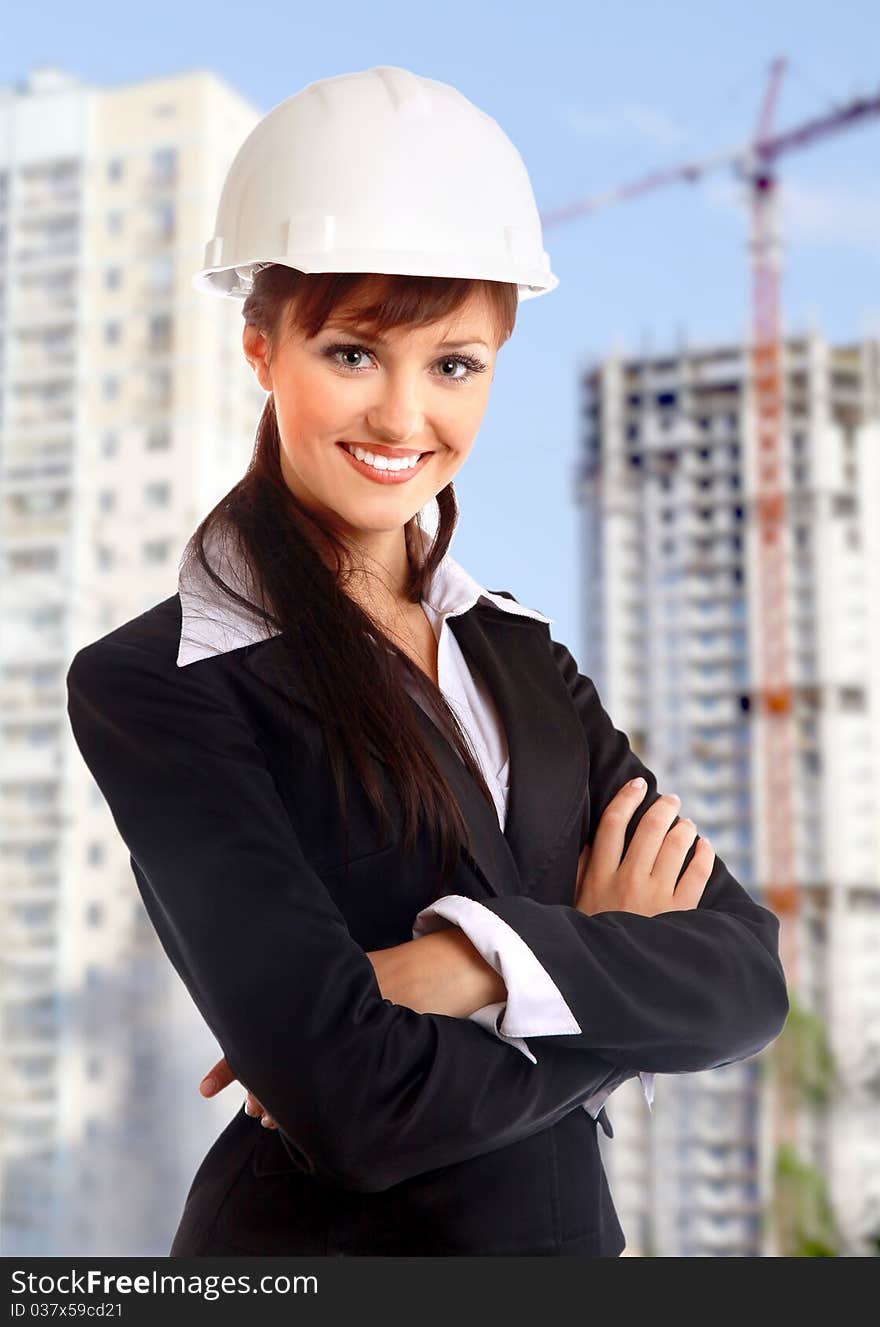 Smiling young female architect holding blueprints