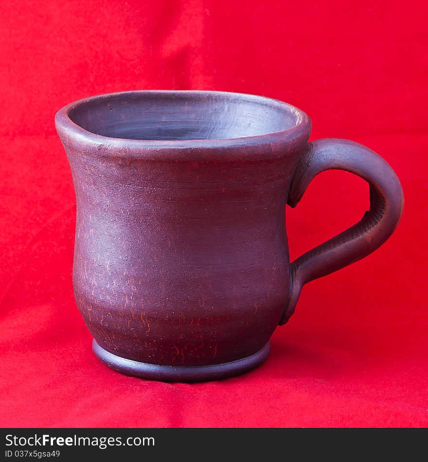 Clay mug on red background