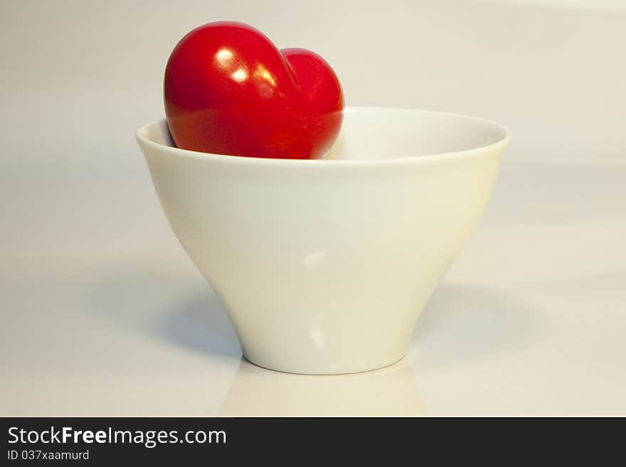 A heart looks out from a white bowl. A heart looks out from a white bowl