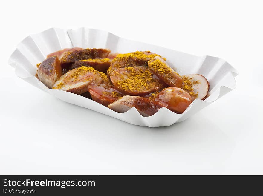 Curried sausages on a paper plate