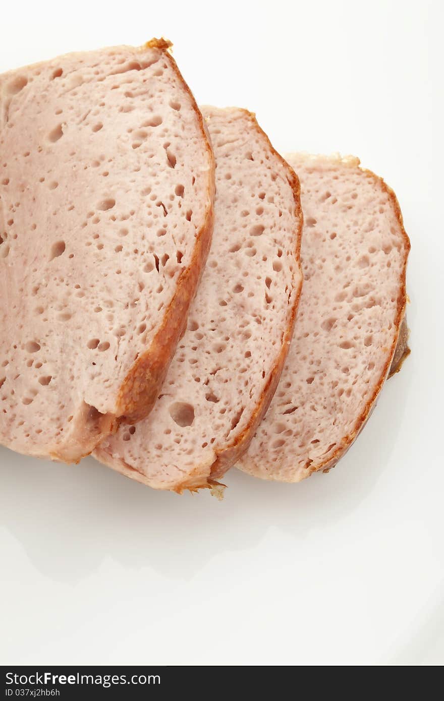 Three slices of baked meatloaf on white background