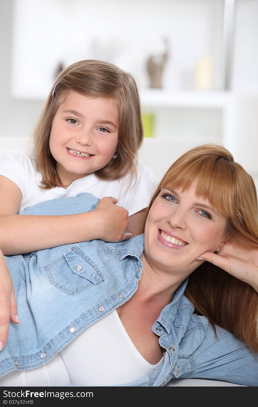 Woman and girl laid on a sofa. Woman and girl laid on a sofa