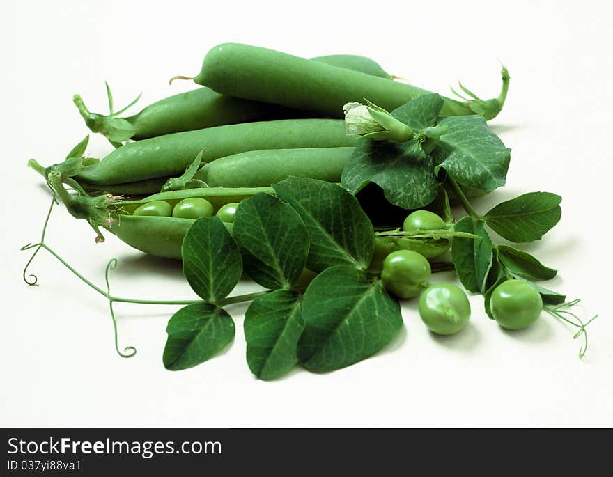 Group of green peas with foliage and flower