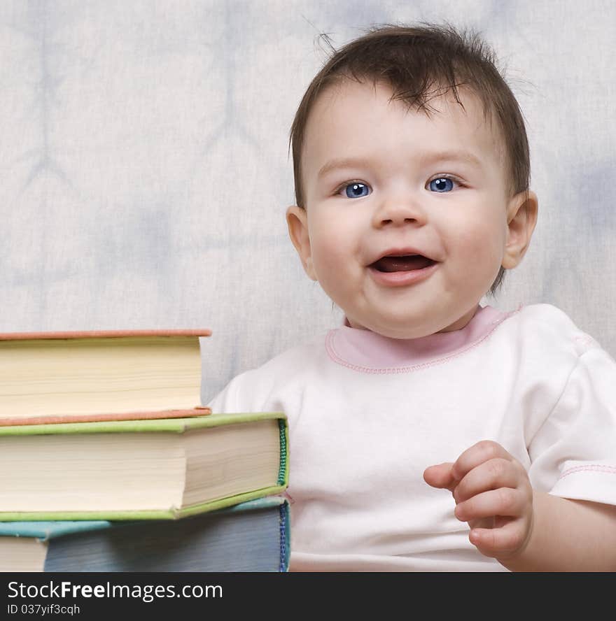 The small child with books on a light background