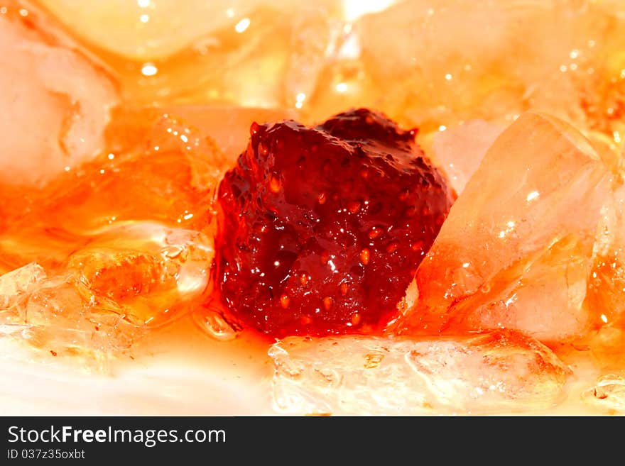 Red strawberry jam and some pieces of yellow ice. Red strawberry jam and some pieces of yellow ice