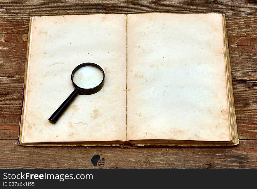 Old book with blank yellow stained pages on wood background