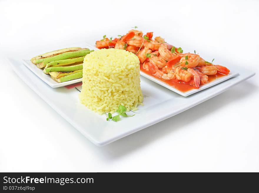 Shrimps in tomato sauce with rice and zuchinni on white plate and background.