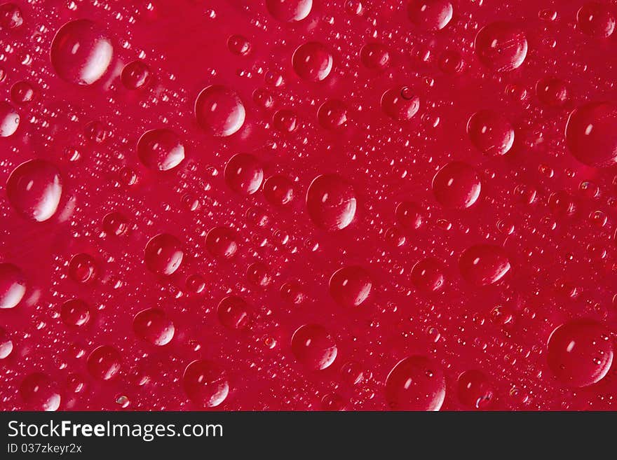 Many drops of water on red background