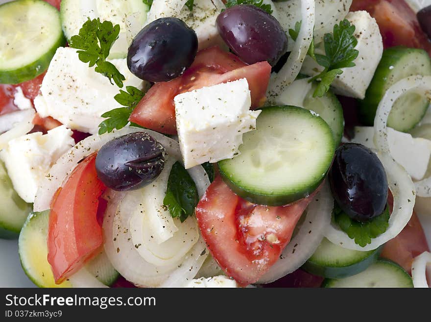 Greek salad inside a white plate and a white background