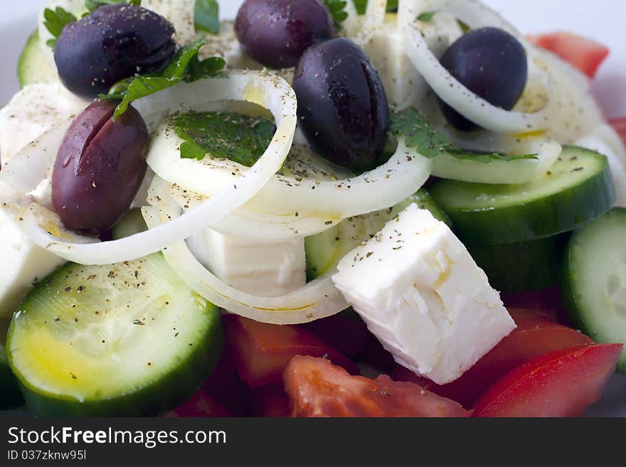 Greek salad inside a white plate and a white background