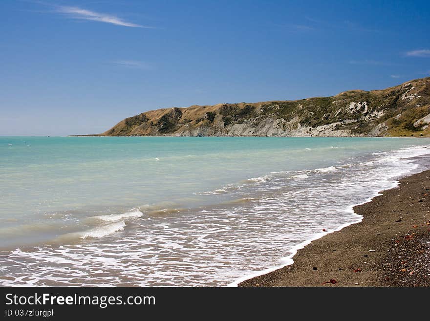 Gravel beach with cliff on background