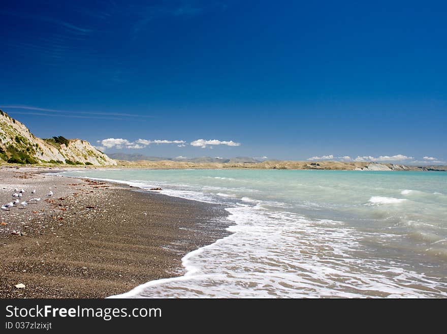 Gravel beach with cliff on background