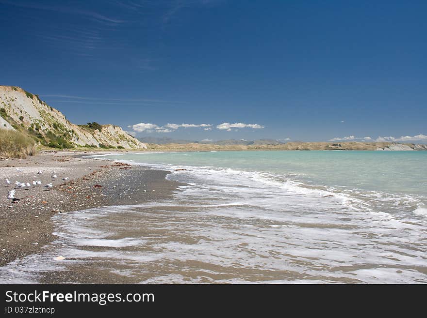 Gravel beach with cliff on background