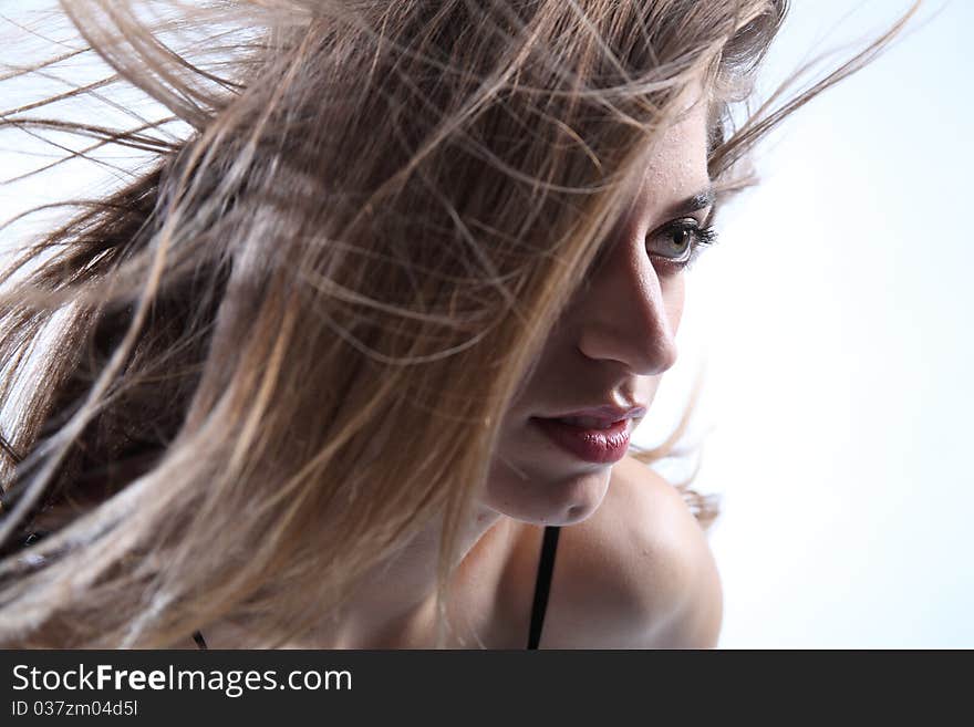 Headshot of beautiful young girl with long brown hair flying around her face. Headshot of beautiful young girl with long brown hair flying around her face.