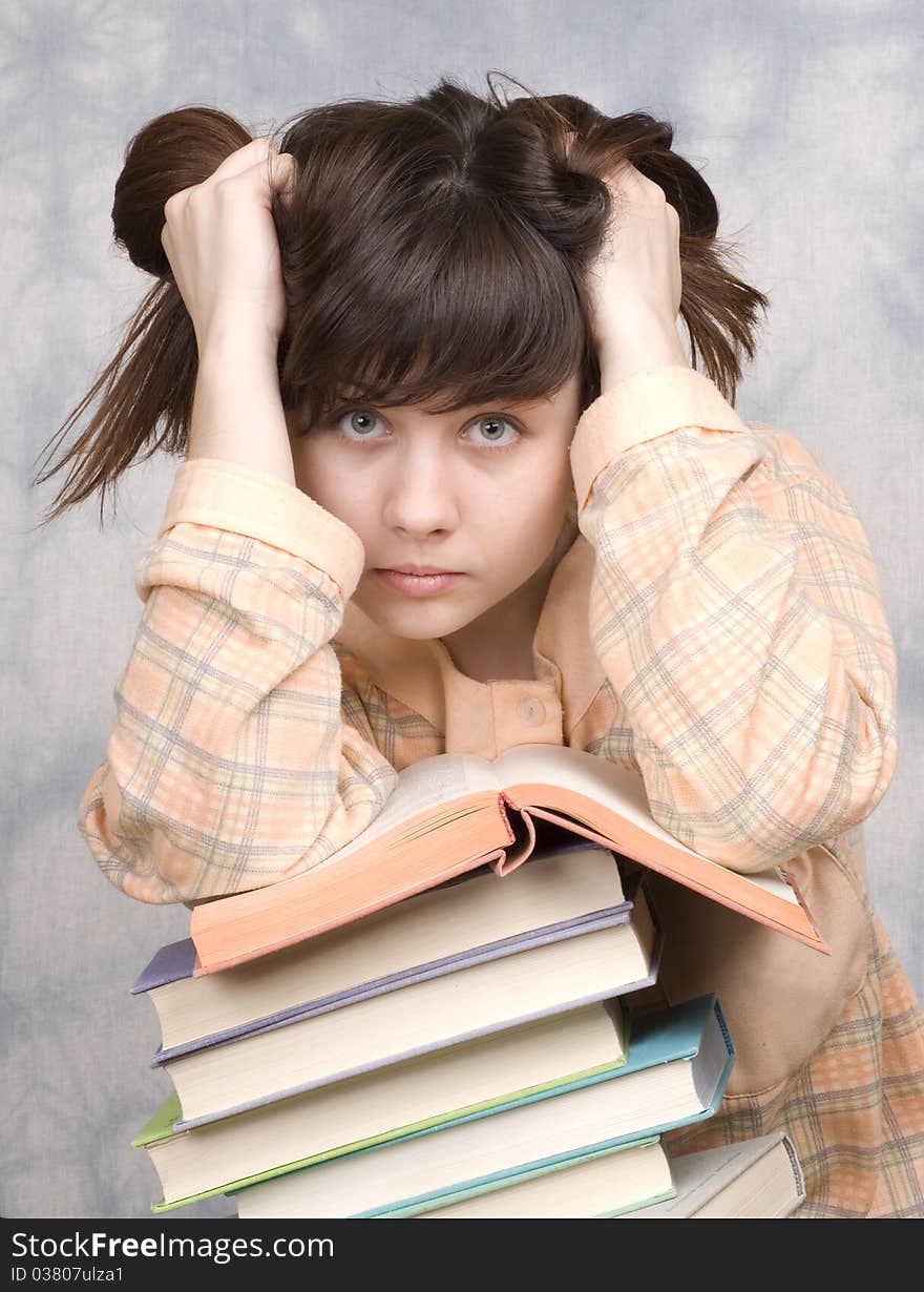 The young girl with books on a light background