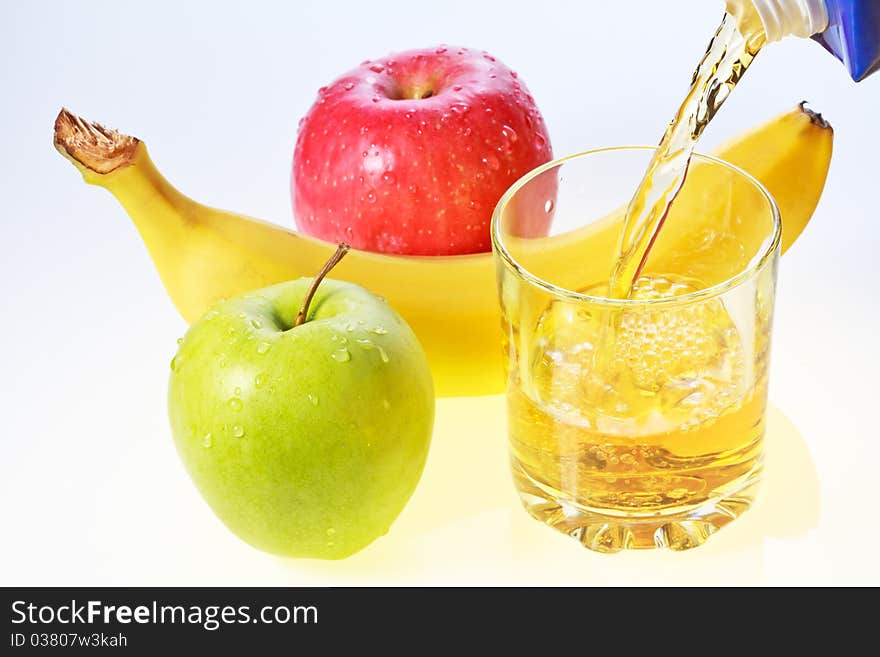 Banana, green and red apples and glass of juice