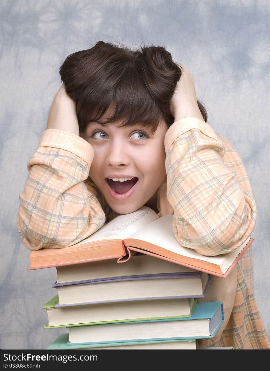 The young girl with books on a light background