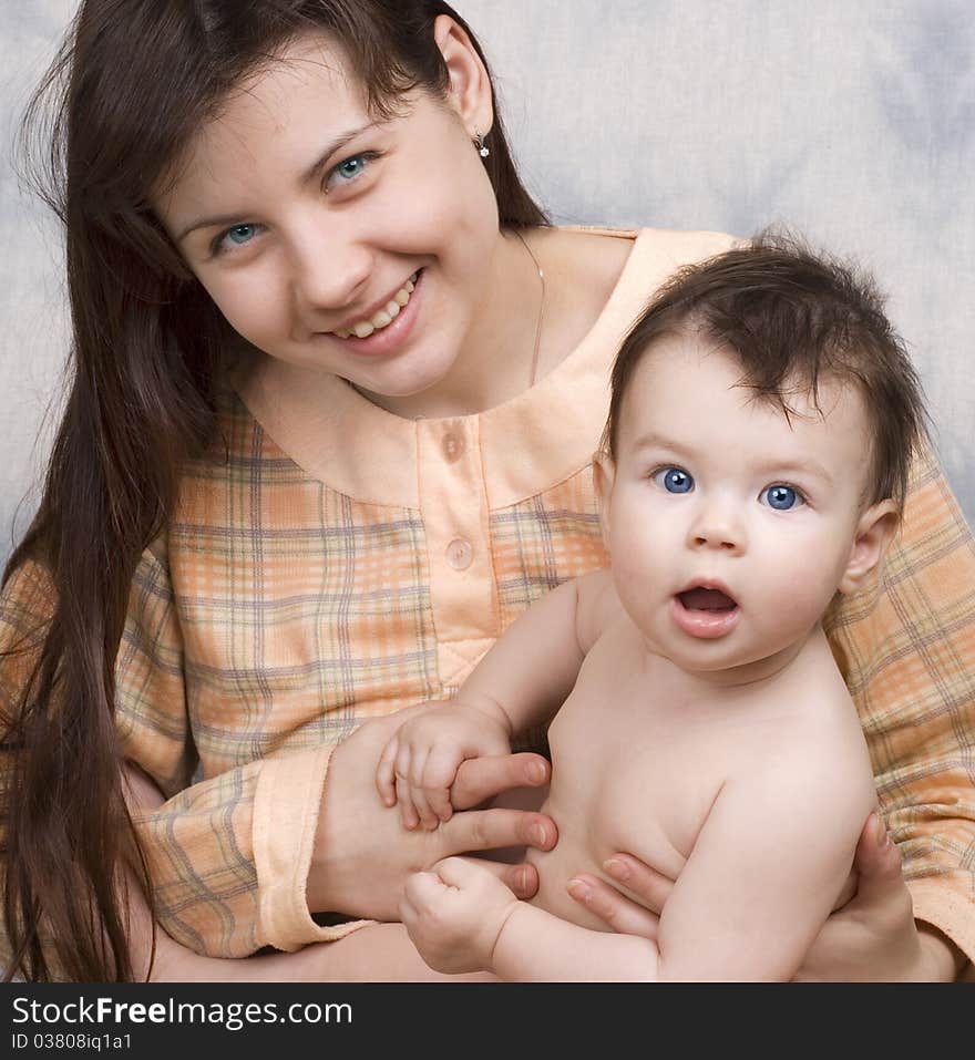 The young woman with the child on light a background