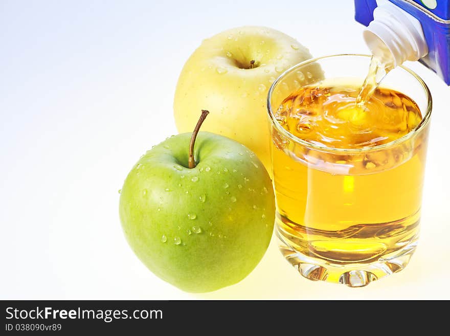 Green and yellow apples and glass filling with apple juice. Green and yellow apples and glass filling with apple juice