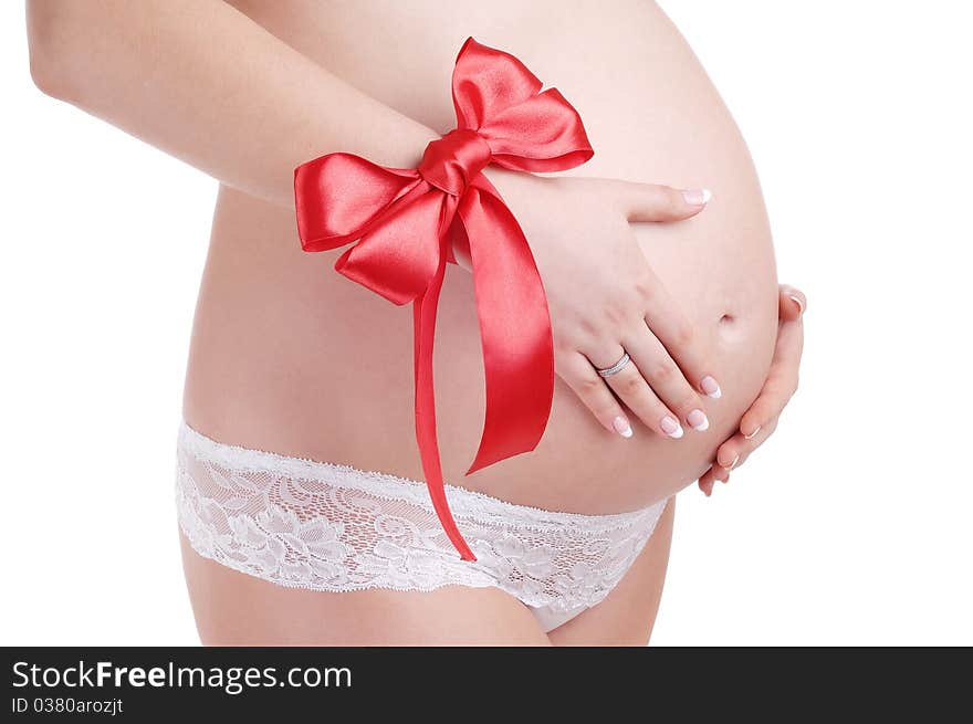 Pregnant woman belly and red bow isolated on a white background. Pregnant woman belly and red bow isolated on a white background