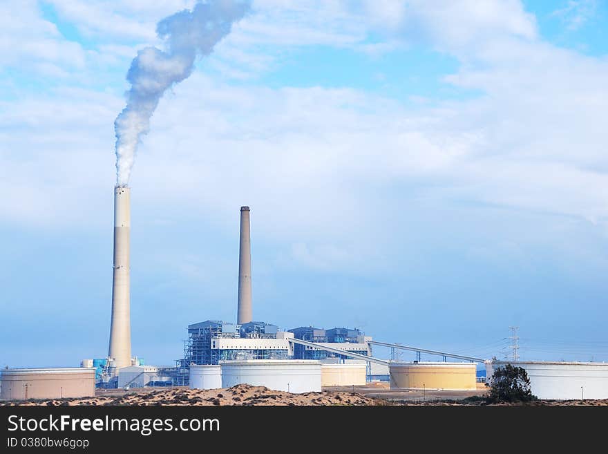 Smokestacks of power station on sky background